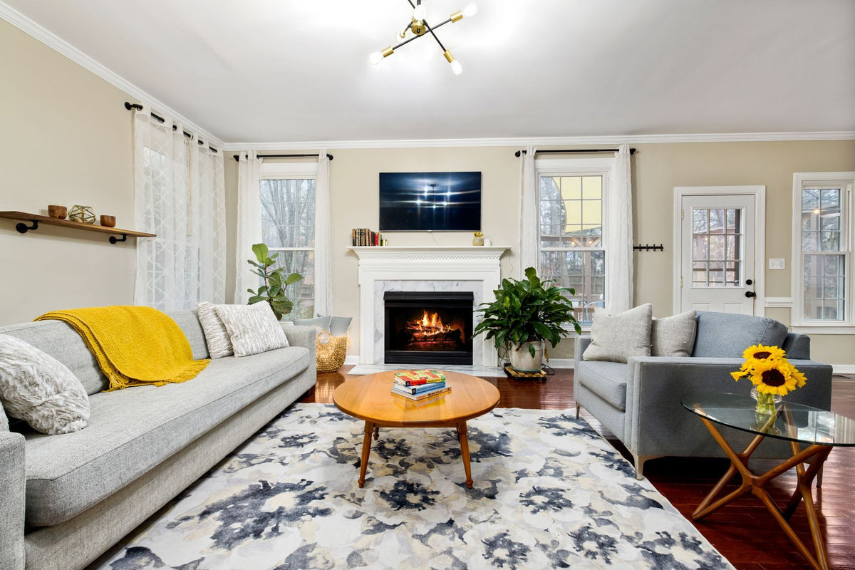 Bright living room interior with a fireplace, modern sofa, and stylish decor creating a cozy atmosphere.