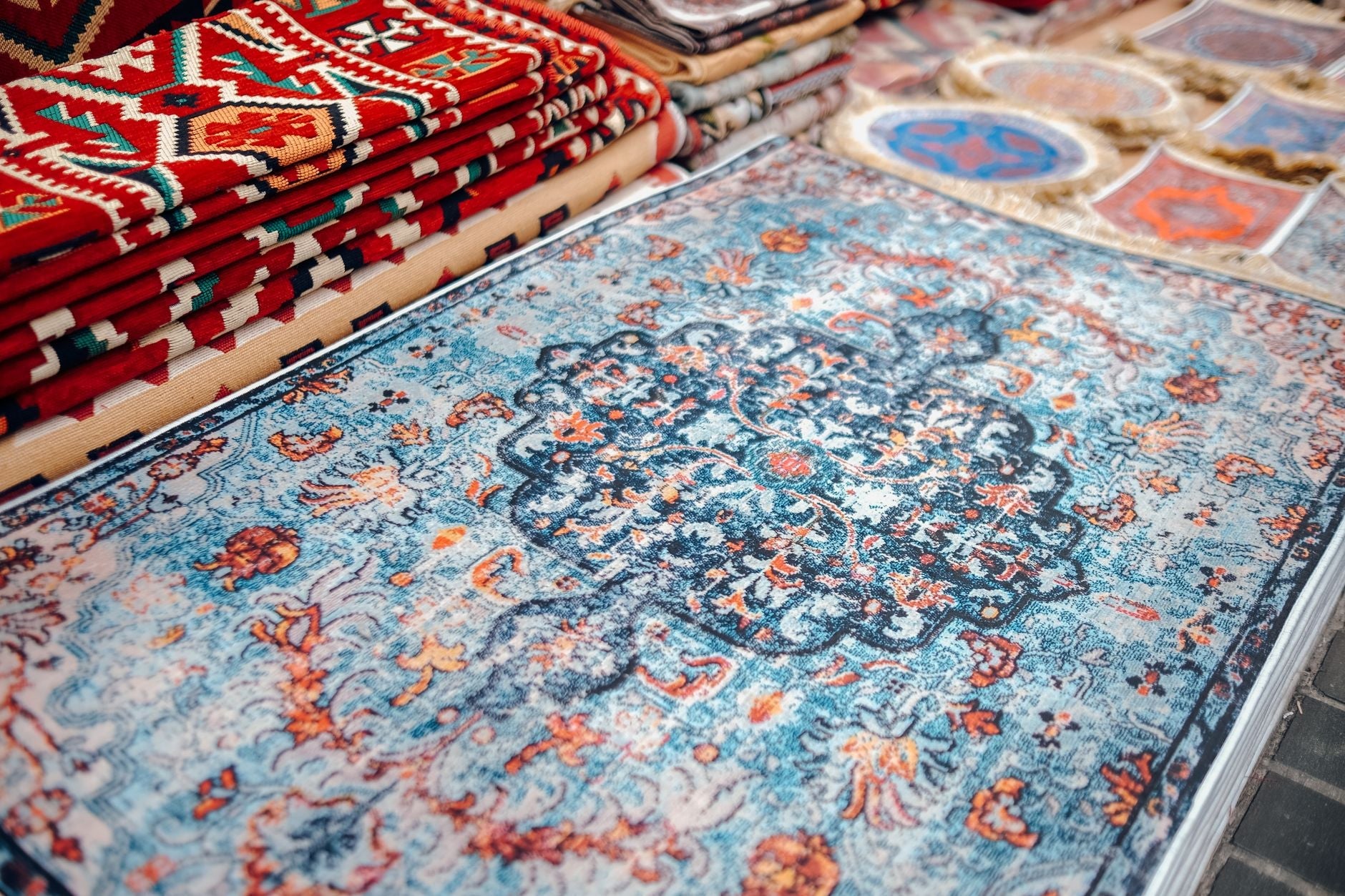 A collection of traditional handmade carpets with vibrant patterns on display.