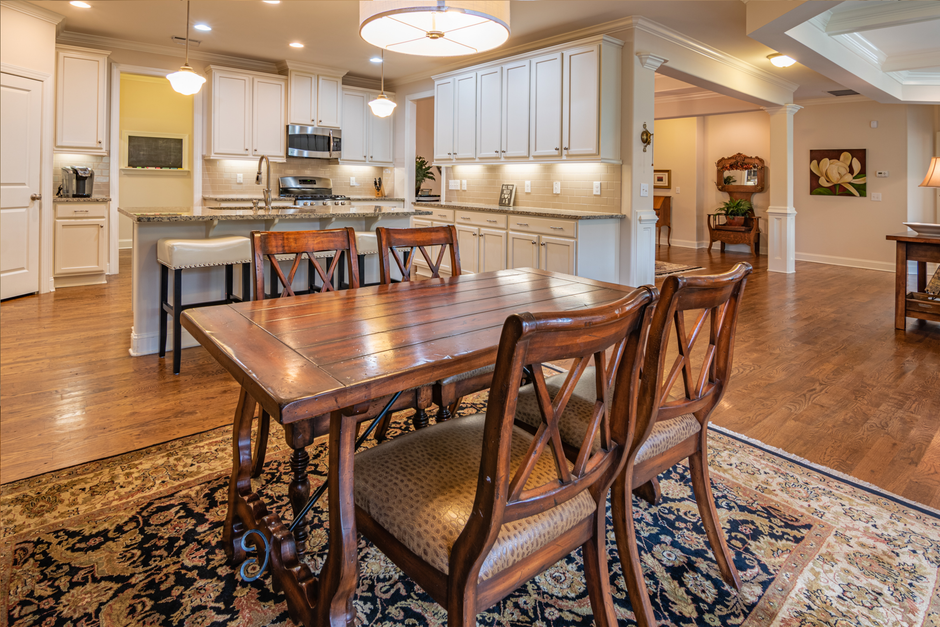 Classic dining room featuring a wooden table, chairs, and a gourmet kitchen setup.