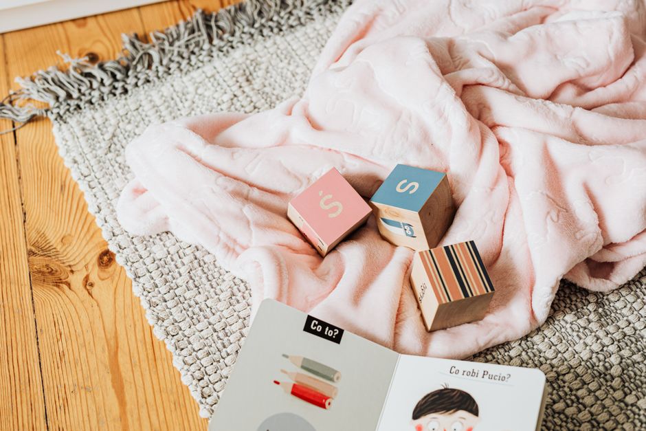 A cozy setup with educational blocks and a children's book on a woven rug.